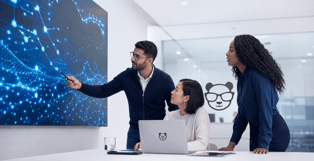 Team colleagues working on a project and looking at a screen