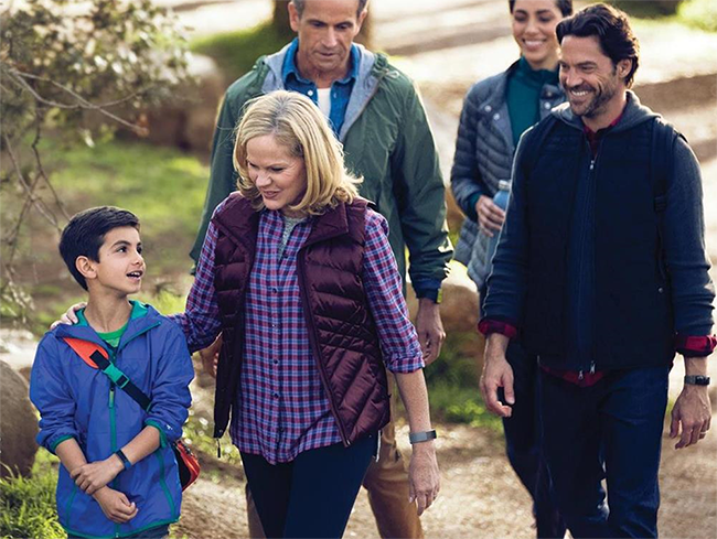 A family take a walk while wearing Fitbits