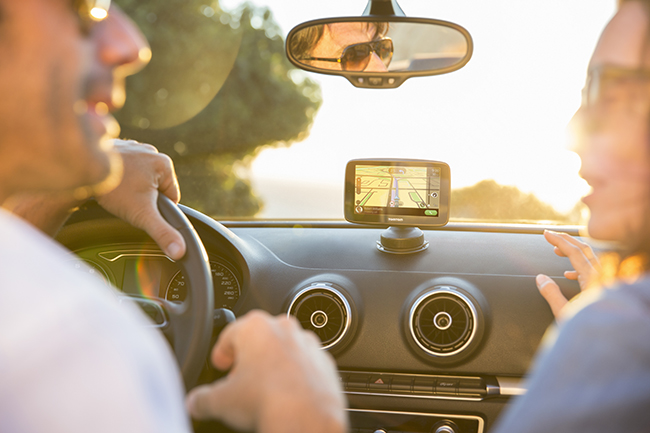 TomTom a couple drives a car with a TomTom on the dashboard